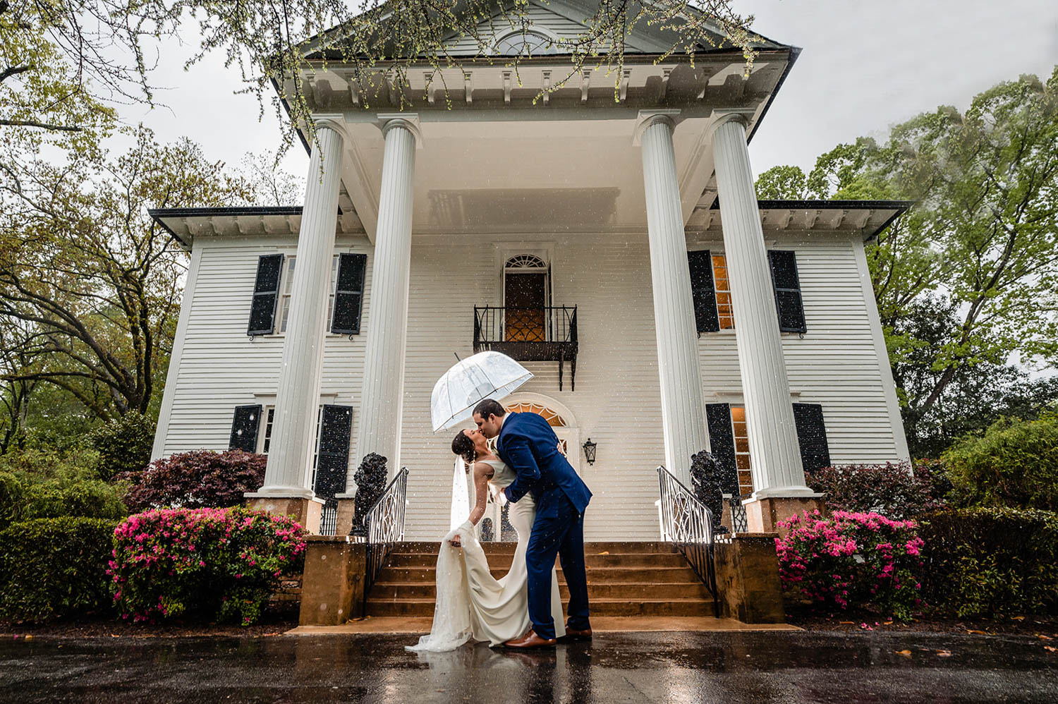 Couple kissing on steps of a large wedding venue