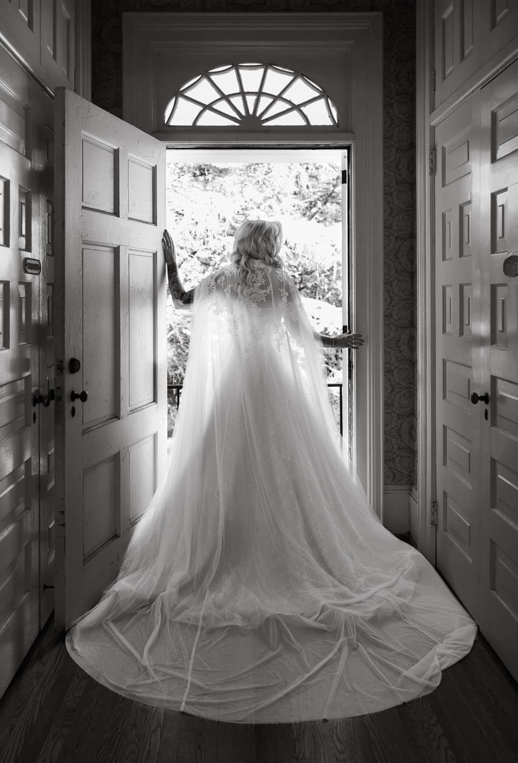 Bride in wedding dress standing in front of a window