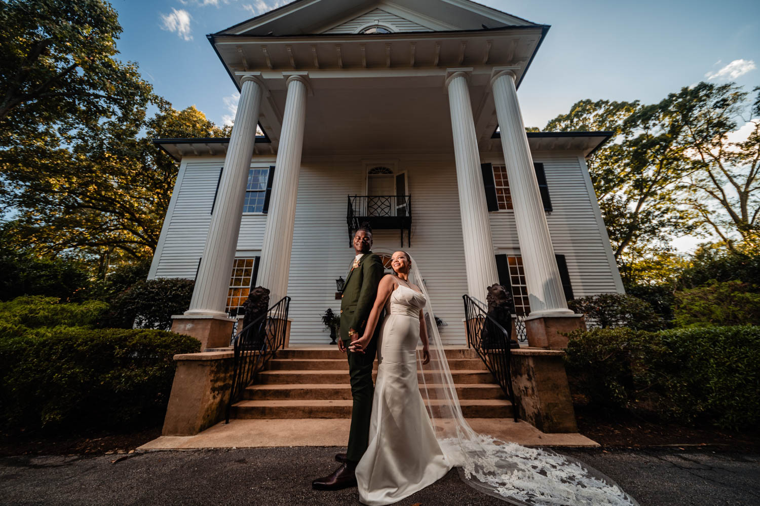 Couple holding hands and standing at the bottom of the steps of a wedding venue