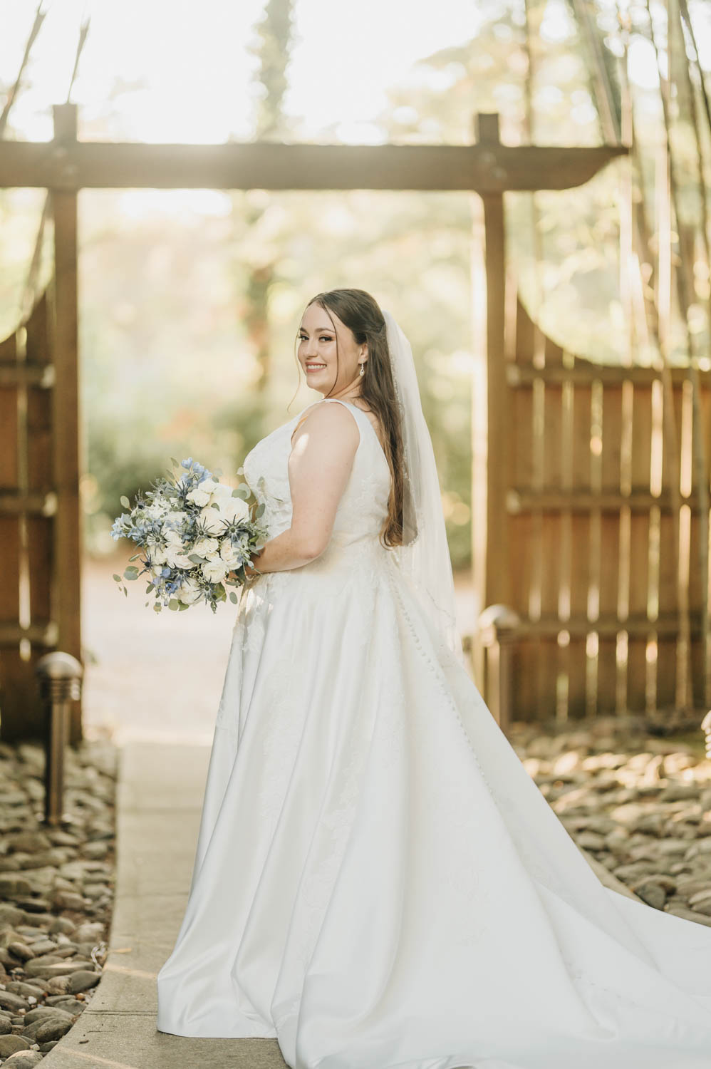 Woman taking bridal portraits next to a fence