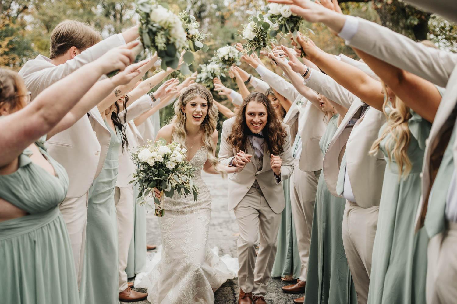 Wedding couple running through a tunnel of arms