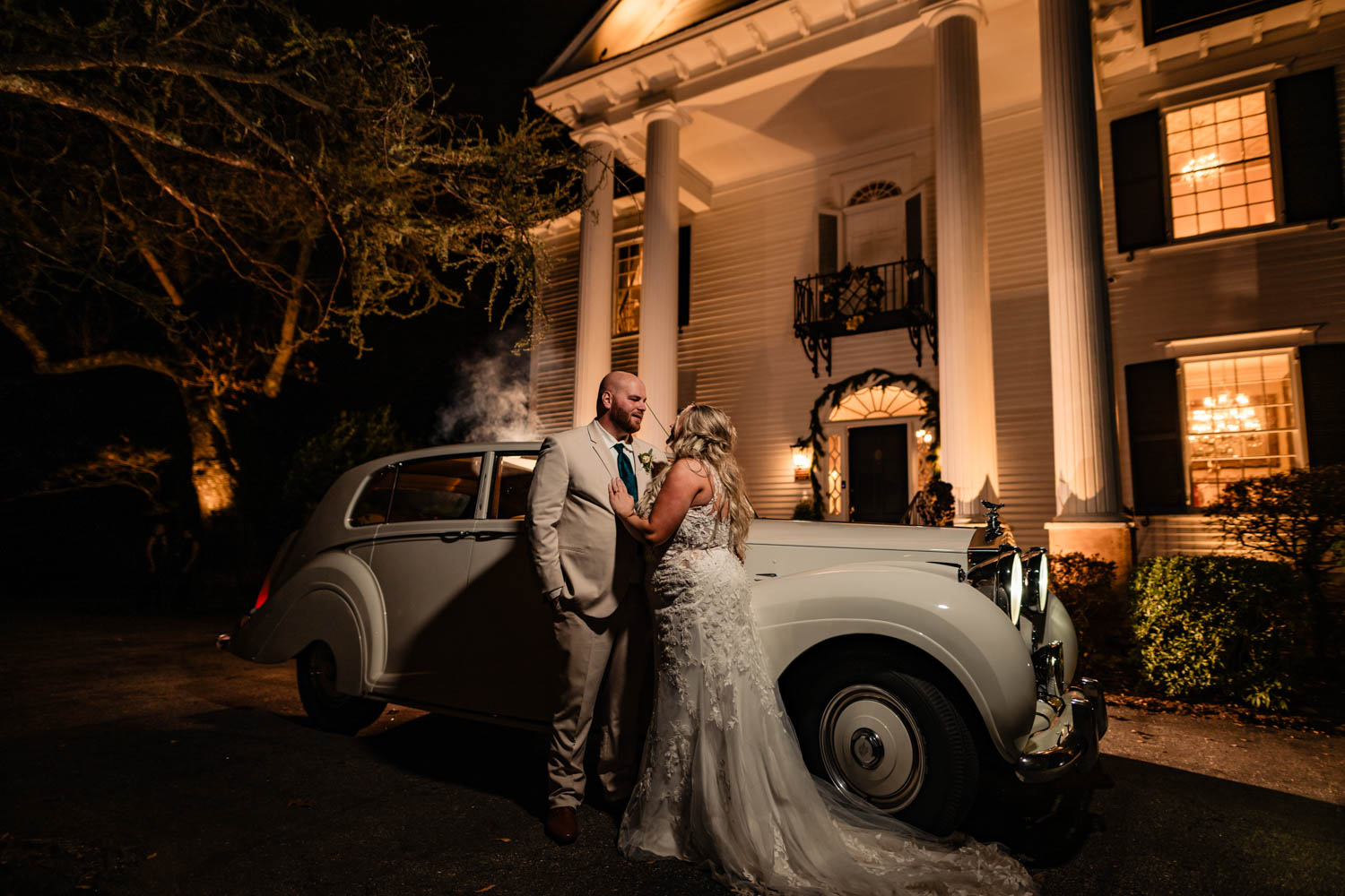 Old car with a married couple in front of Duncan Estate