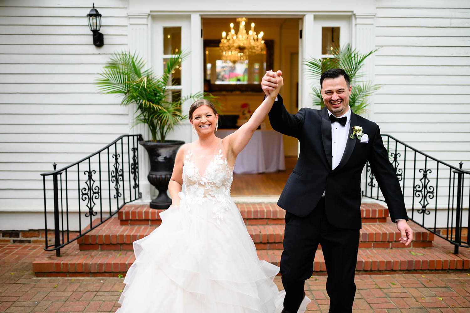 newly married couple with hands held in the air after ceremony