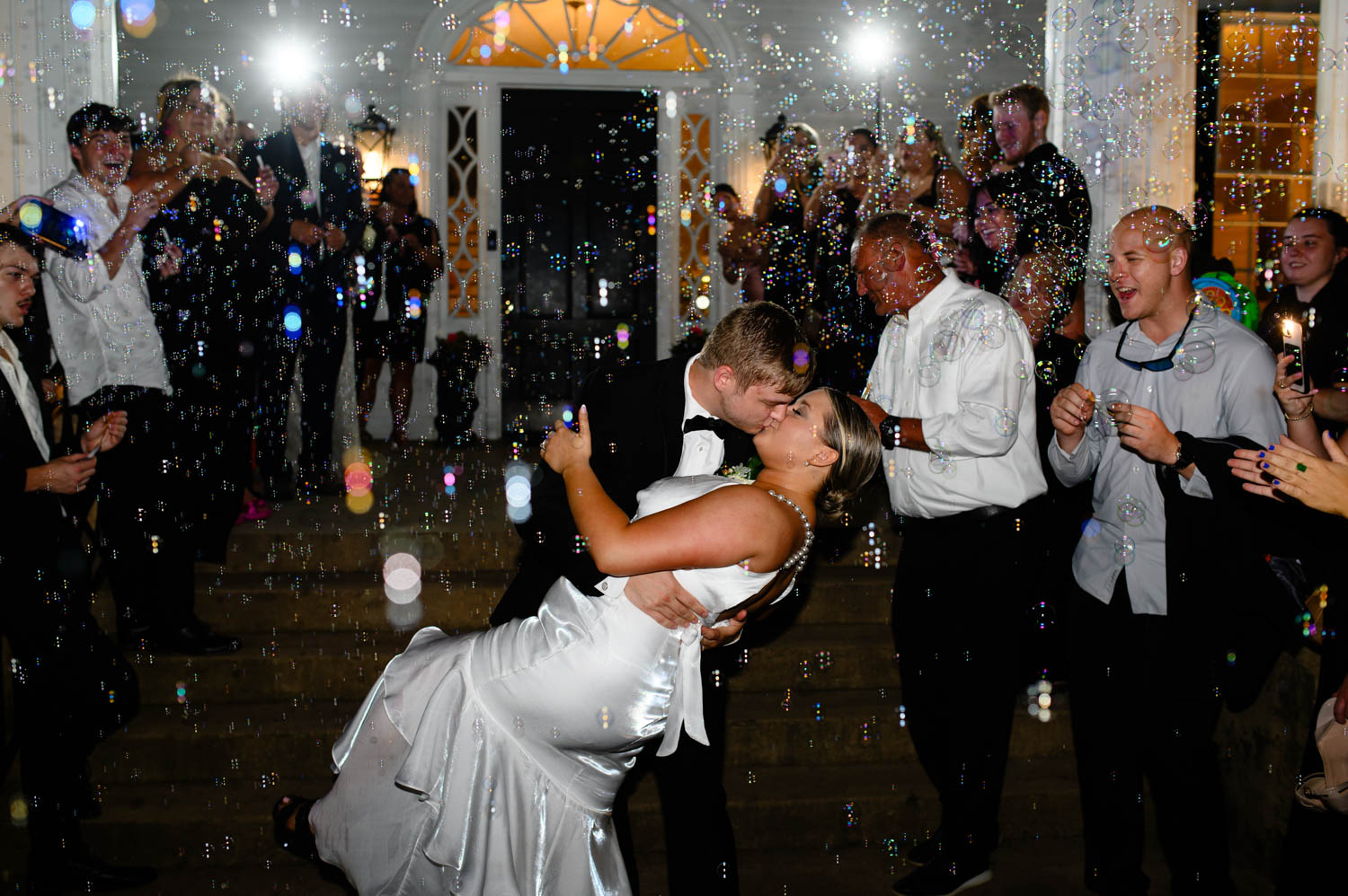 Just married couple kissing while dipping at wedding reception