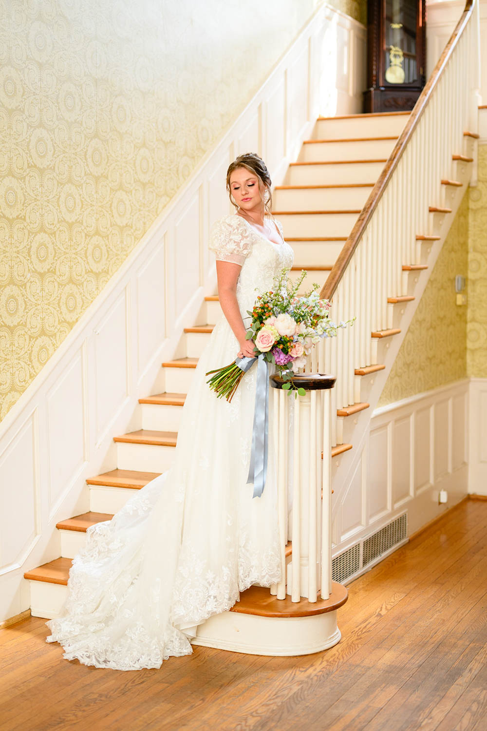 Woman in wedding dress standing on wooden stairs