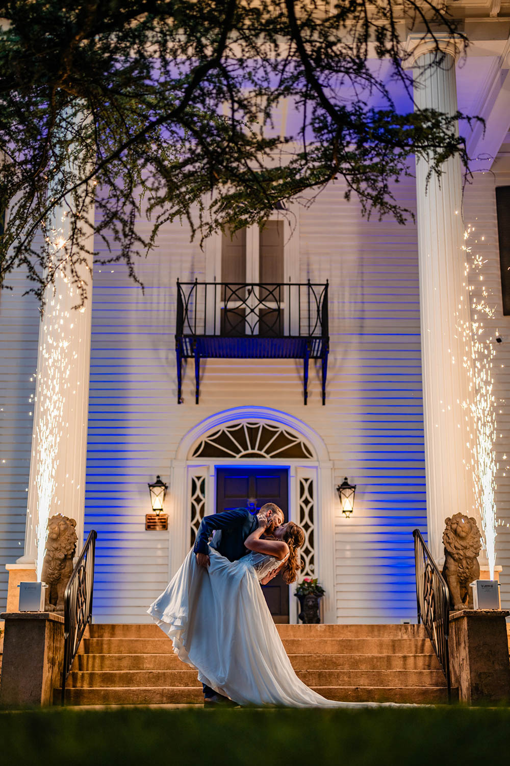 Bride and groom in wedding attire, posing in front of the grand Duncan Estate.