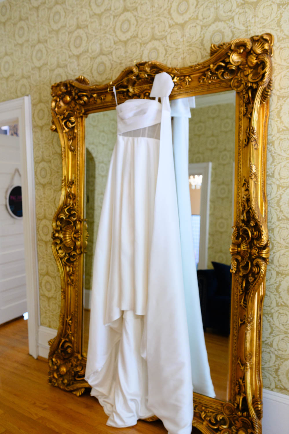 Wedding dress hanging in front of a mirror