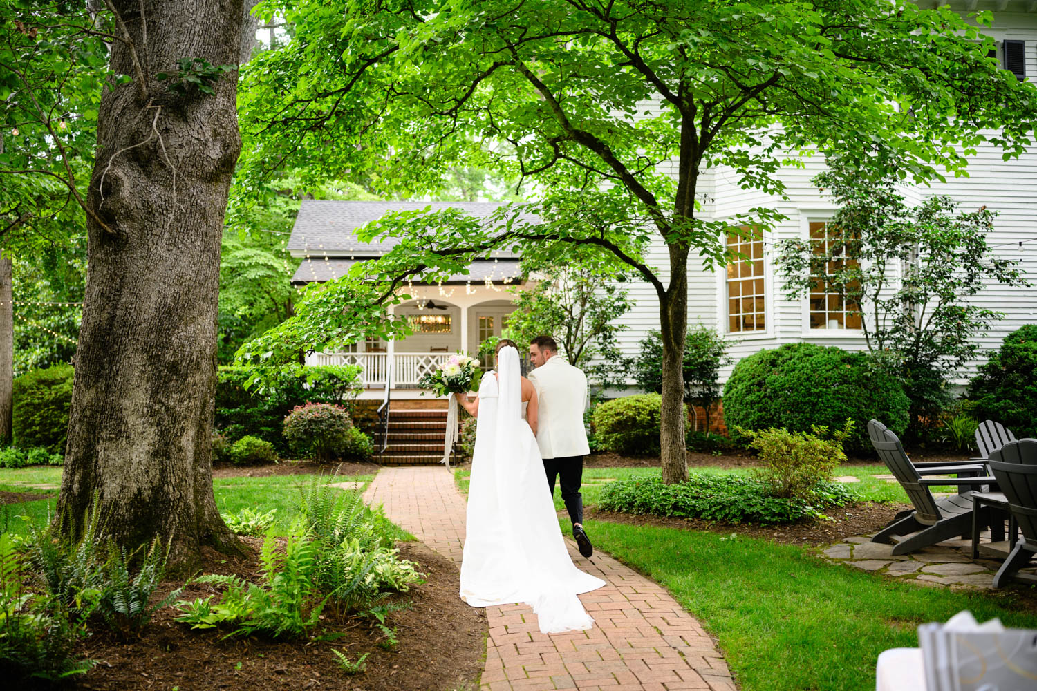 Duncan estate wedding couple walking down a brick path away from the camera