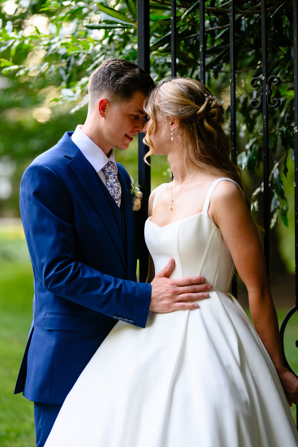 Wedding couple leaning against a tree with eyes closed