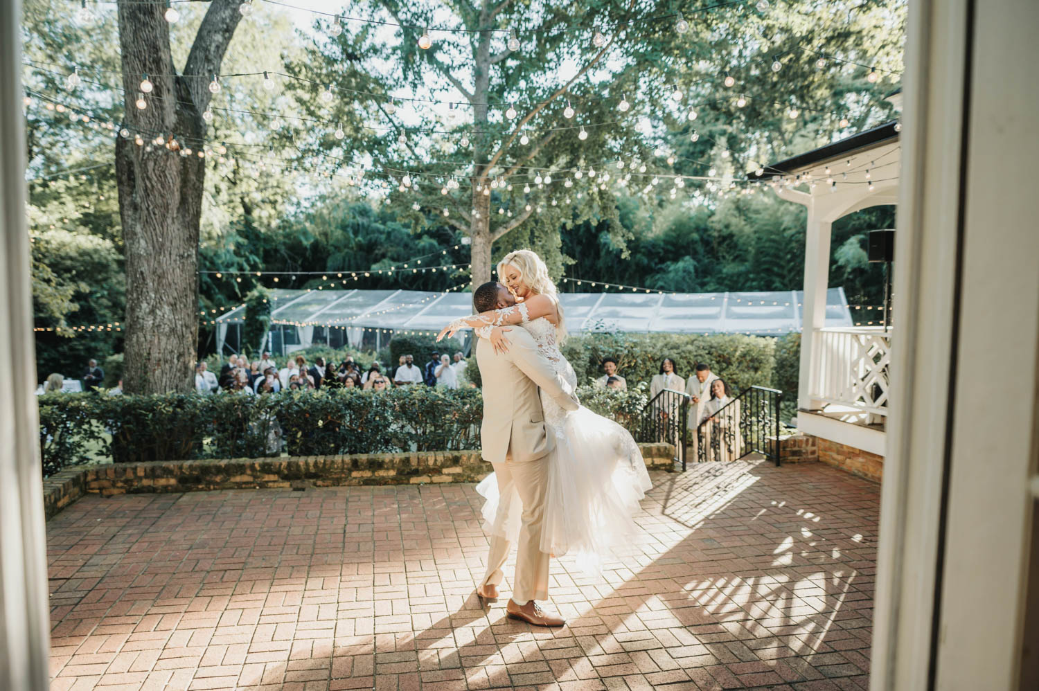 Groom picking up bride to hug before wedding ceremony