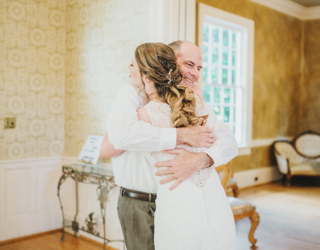 Dad hugging daughter before wedding ceremony